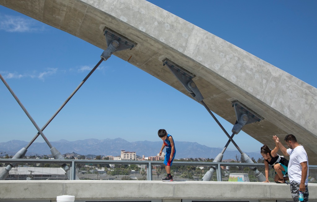 Axel Torres, 5, and sister Dottie, 6, under the watchful eye of dad David, walk along the concrete pedestrian path wall at the 6th Street Viaduct 