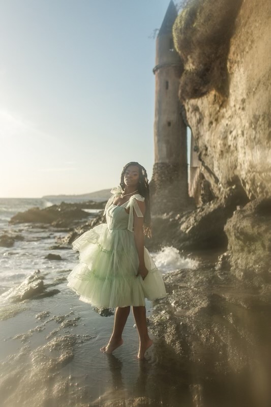 Chazlyn Yvonne posing on a beach in mermaid core fashion.