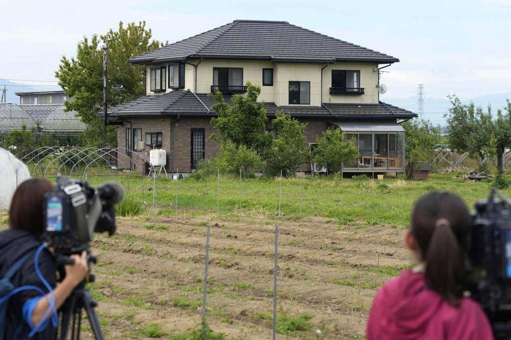Journalists are seen placing cameras near Masanori Aoki's home in Nakano