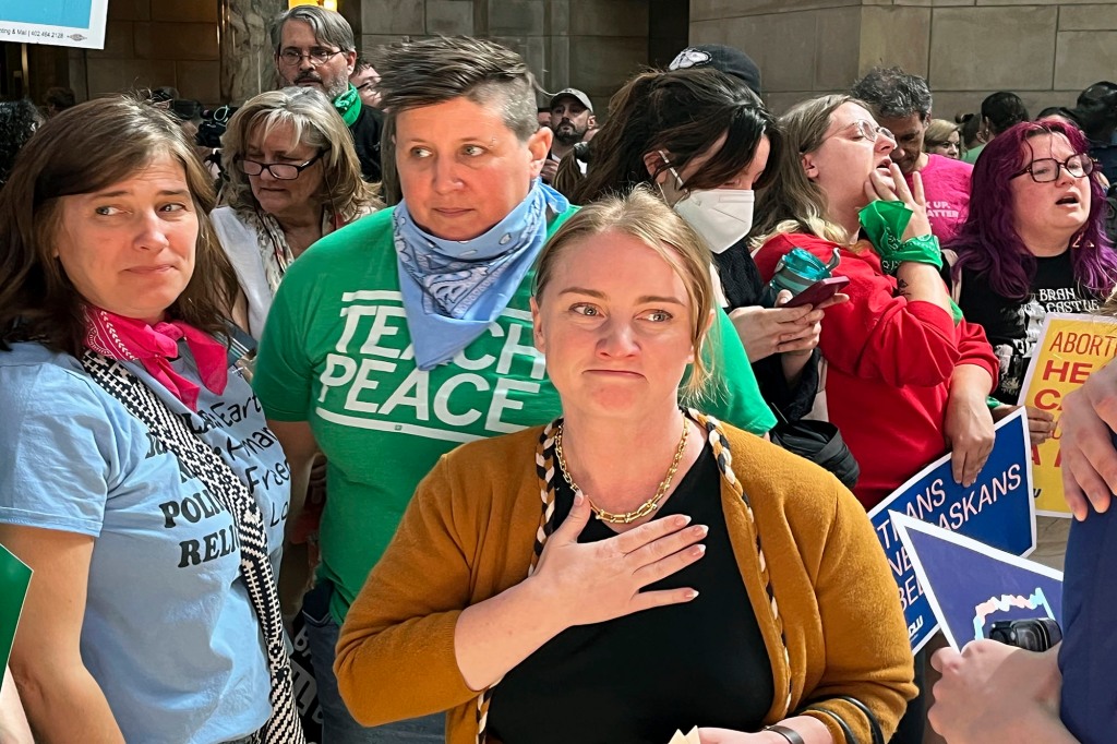 Nebraska state Sen. Megan Hunt, center, stands among supporters minutes after a vote in which the Nebraska Legislature passed a bill to ban abortion at 12 weeks and ban gender-affirming care in minors, Friday, May 19, 2023 in Lincoln, Neb.