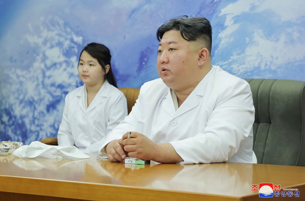 Tuesday’s visit showed Kim and his daughter – dressed in white lab coats – talking with scientists near an object that looked like the main component of a satellite. 