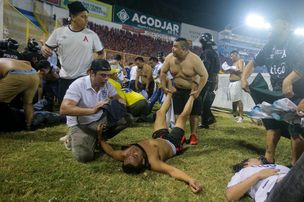 Soccer fans are assisted by others fans at the field of the Cuscatlan stadium in San Salvador, El Salvador, on May 20, 2023.