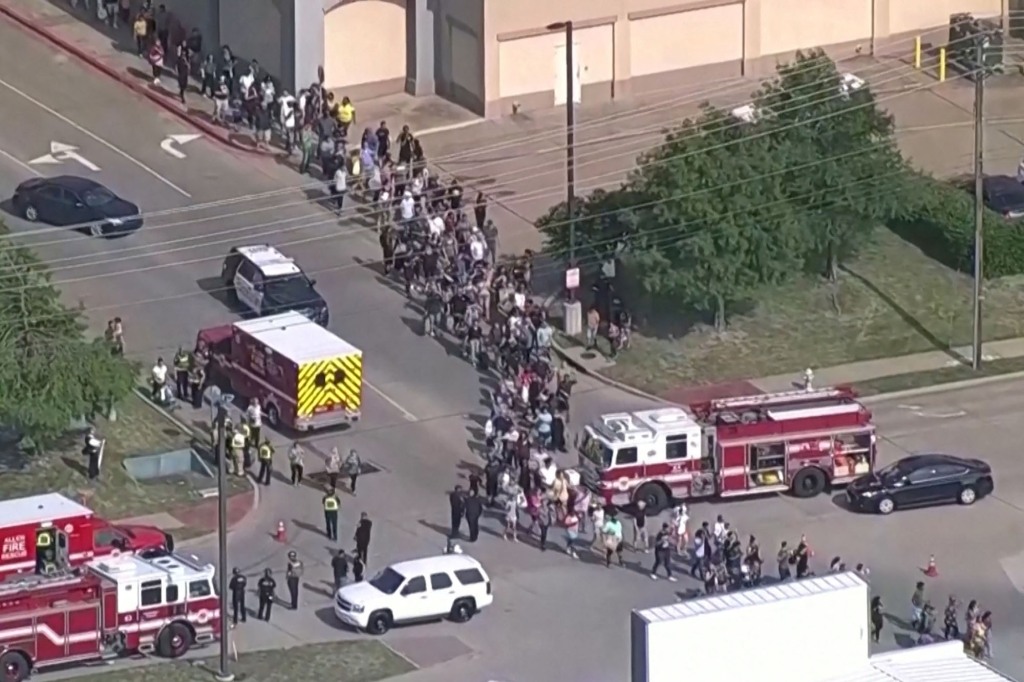 Shoppers leave as law enforcement officers respond to a shooting in the Dallas area's Allen Premium Outlets, which authorities said has left multiple people injured in Allen, Texas, on May 6, 2023.