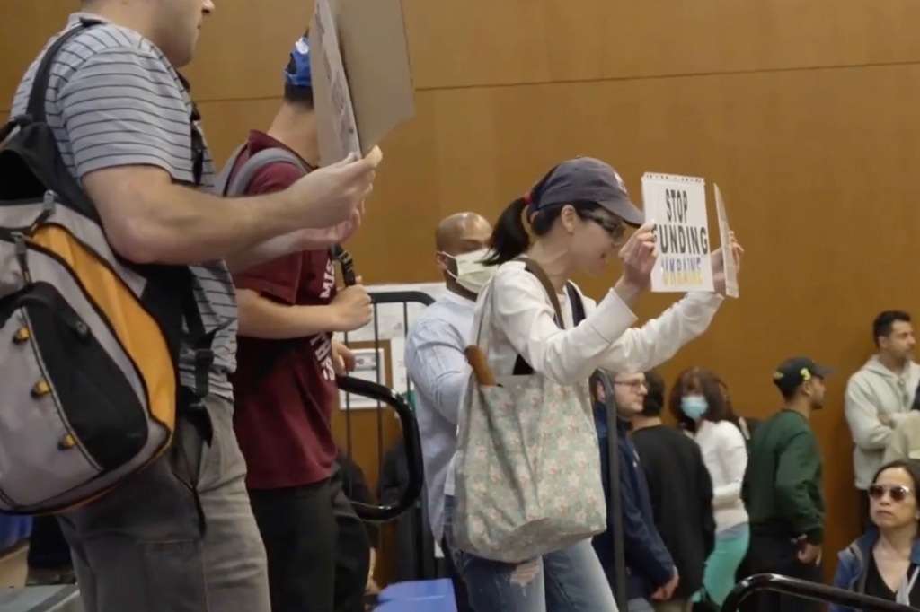 Town hall attendees held signs opposing Ocasio-Cortez.