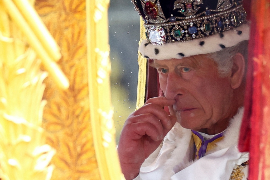 King Charles sniffing his royal "sausages" in the golden carriage after being crowned at Saturday's coronation.