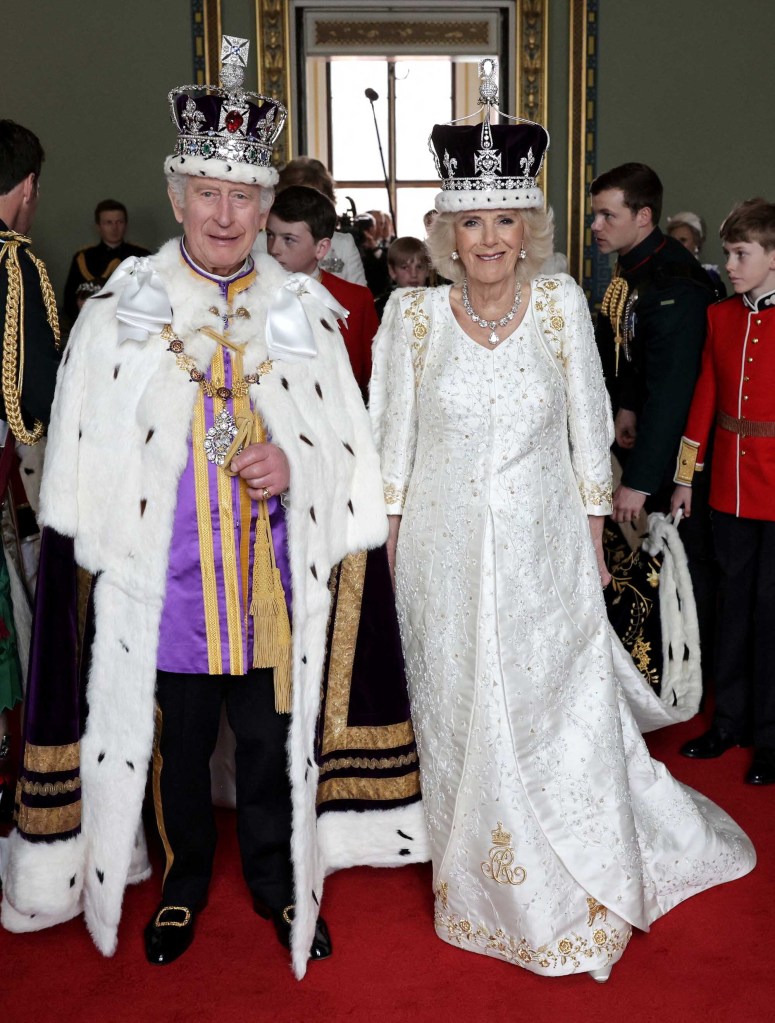 Camilla and Charles grin from ear to ear while sporting their royal robes just before they appear on the palace balcony on Saturday. 