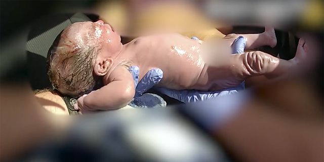 deputy holding newborn baby