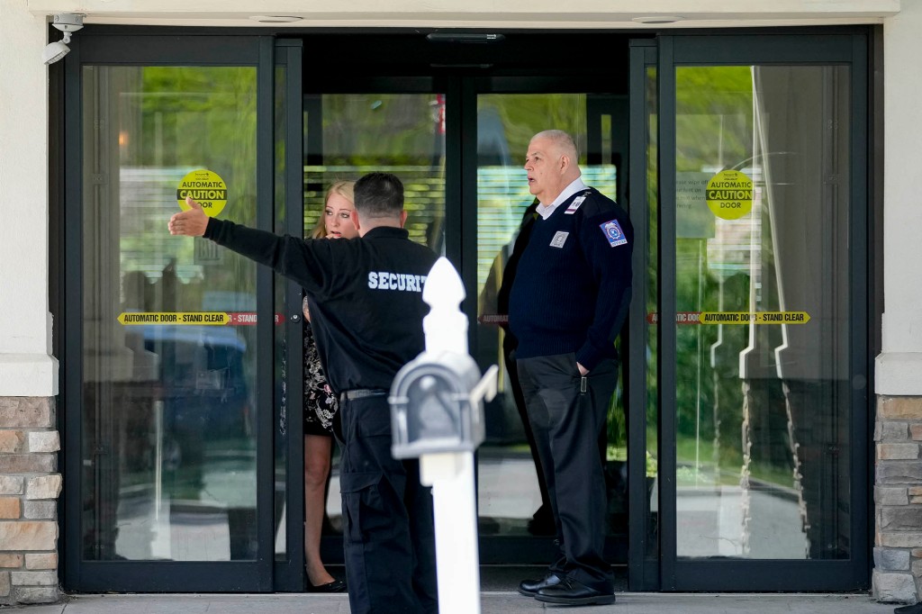 Security and staff personnel mill around The Crossroads Hotel where two busloads of migrants arrived hours earlier, Thursday, May 11, 2023, in Newburgh, N.Y