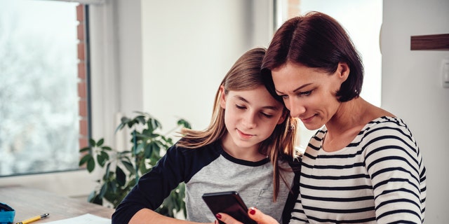 Mom teaching daughter on phone