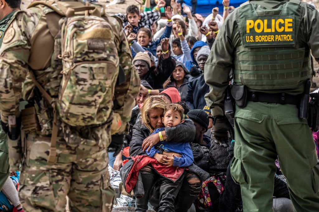 Border patrol selecting people, mostly women and children for processing.