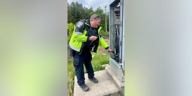 officer looking inside electrical box