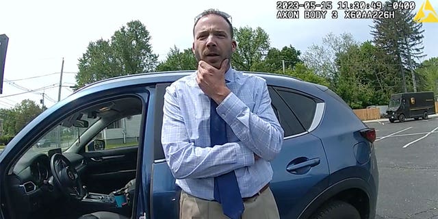 Matthew Reilly is questioned by police officers outside of his vehicle