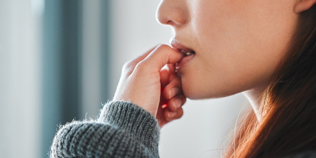 Woman biting nails