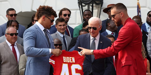 Patrick Mahomes holds jersey for Joe Biden