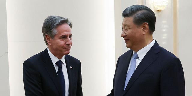 Antony Blinken and Xi Jinping shake hands