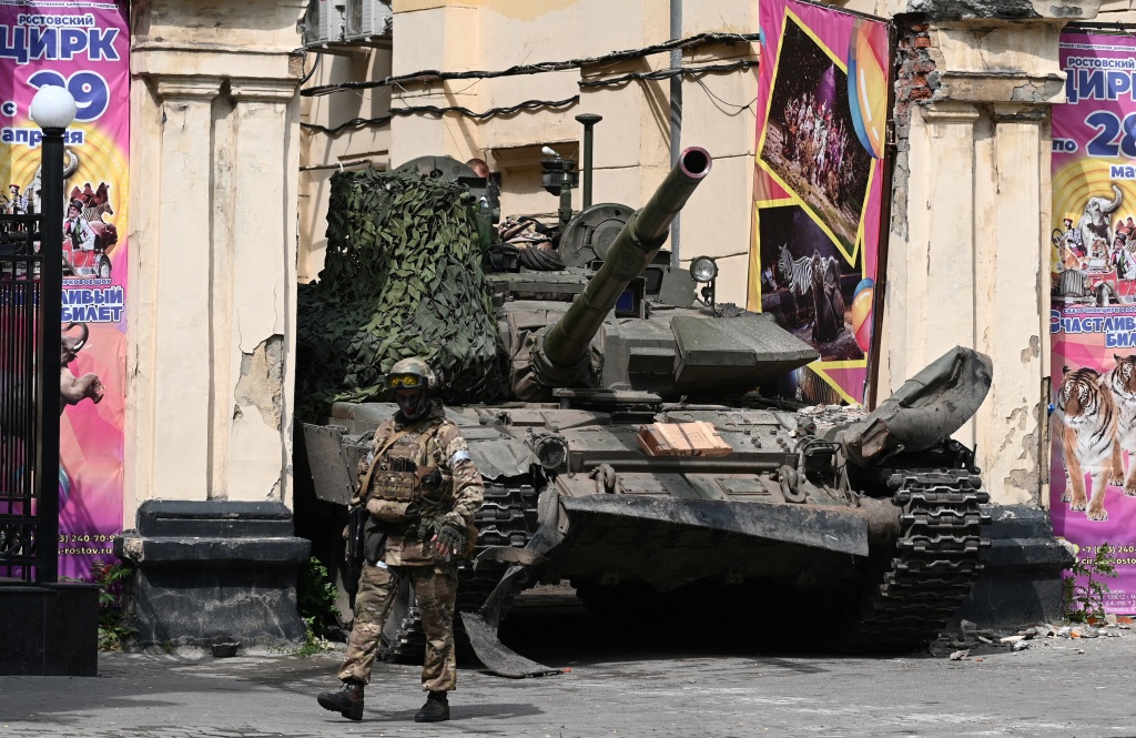 A fighter of Wagner private mercenary group walks past a tank in a street near a local circus in the city of Rostov-on-Don, Russia, June 24, 2023. 