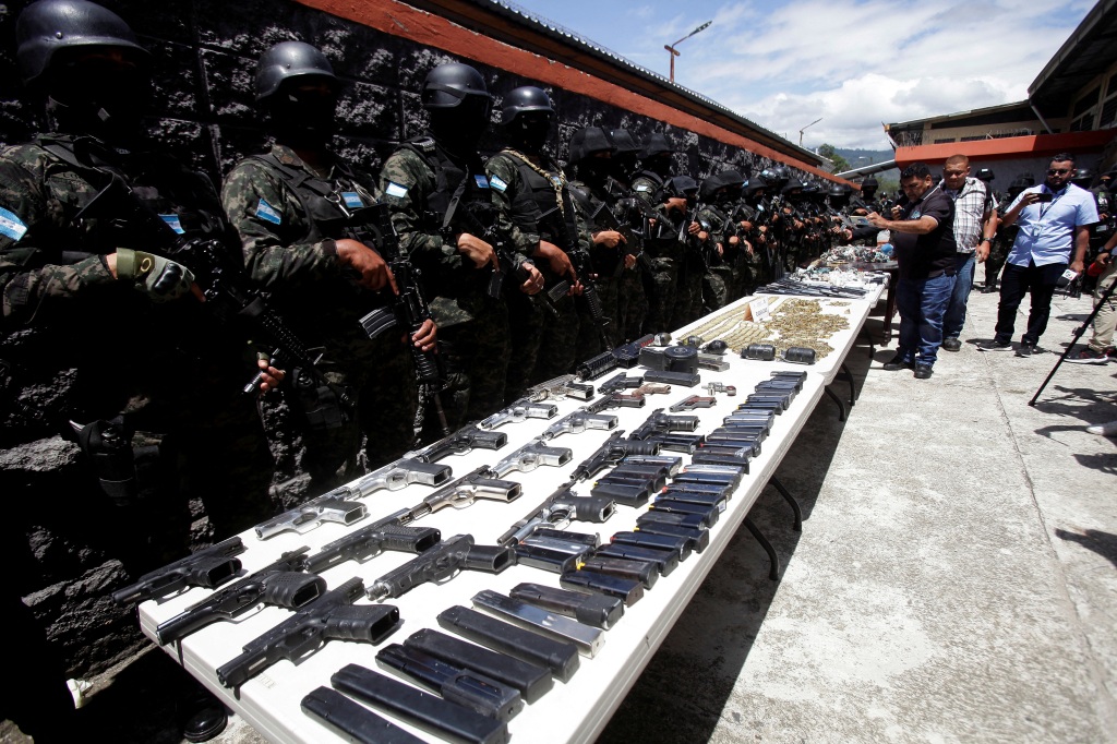 Members of the Military Police of Public Order stand guard as they present bullets, magazines and weapons, seized at Tamara prison on the outskirts of Tegucigalpa, Honduras on June 26, 2023. 