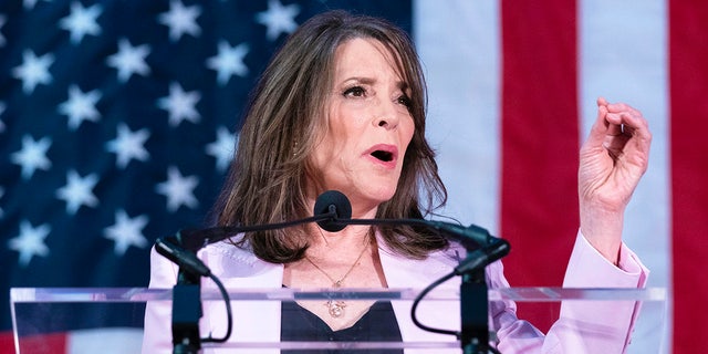 Marianne Williamson left hand raised at podium