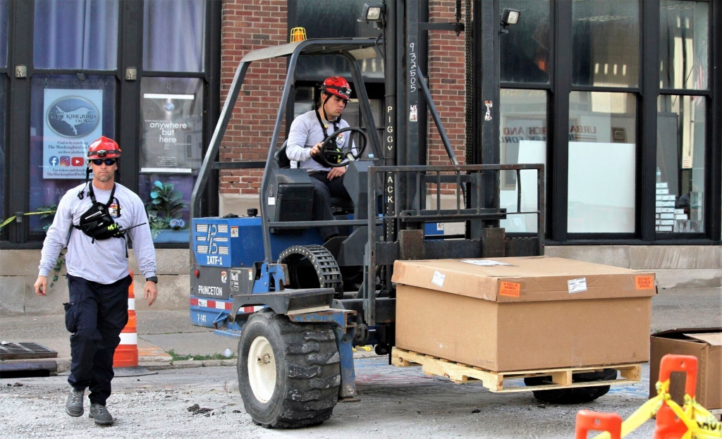 Members of Iowa Task Force 1, Urban Search and Rescue, move their gear into place.