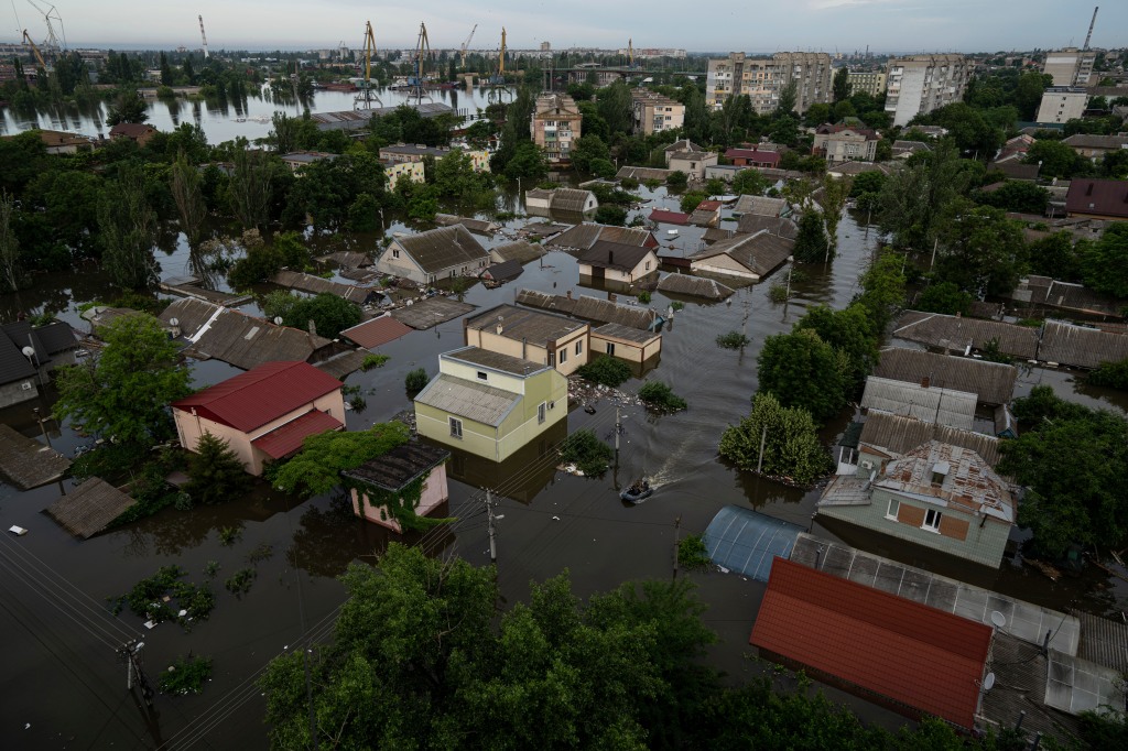 Ukrainian servicemen ride by boat in a flooded neighborhood in Kherson.