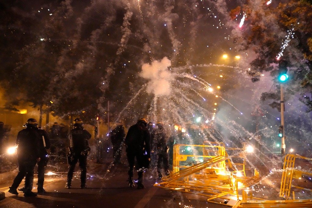 Multiple vehicles were set ablaze in Nanterre and protesters shot fireworks and threw stones at police, who fired repeated volleys of tear gas.