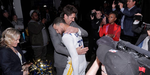 Bob Myers hugs Steph Curry