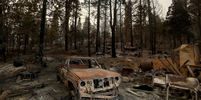 Burned vehicles and remnants of a home from Oak fire