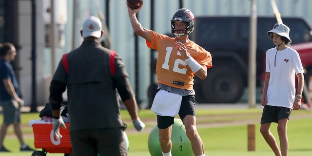 Tom Brady throws a pass as his son looks on