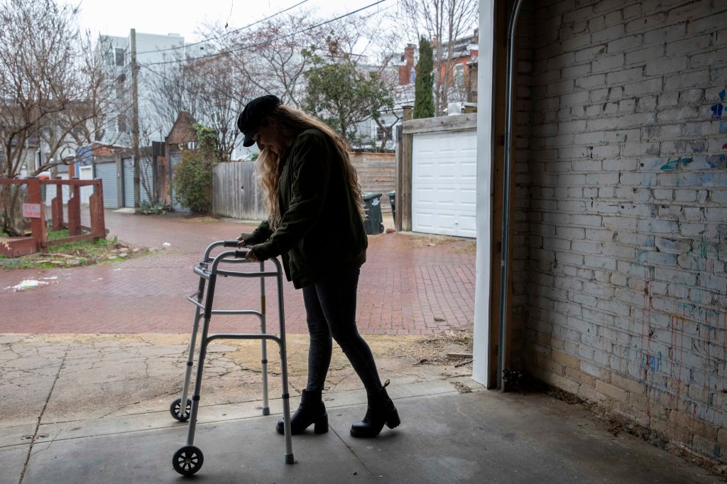 Amber Escudero-Kontostathis holds onto the first walker she used to use at her home in Washington, D.C., on March 10, 2023. 