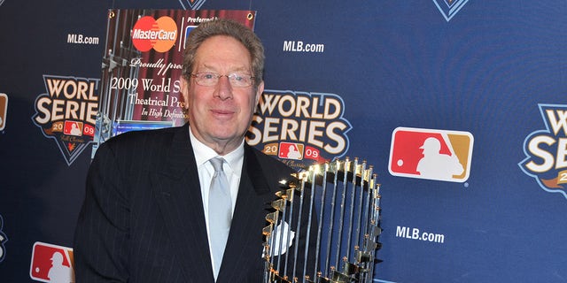 John Sterling poses with World Series trophy