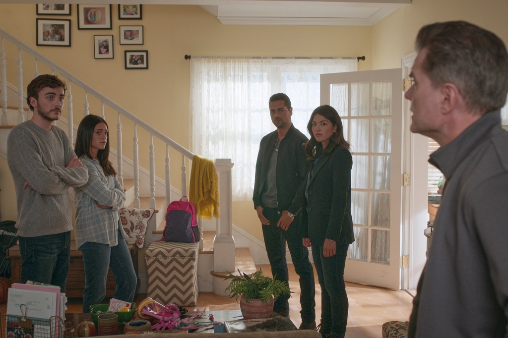 A shot of five characters standing in the living room: Cal (Ty Doran), Olive (Luna Blaise), Jared (JD Vasquez) and Drea (Ellen Tamaki), Jared's partner in the NYPD. Cal and Olive have their arms crossed and they're all looking at a fifth character in the foreground.