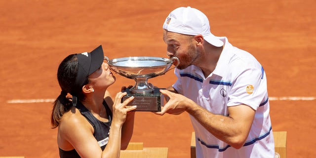 Miya Kato and Tim Puetz kiss trophy