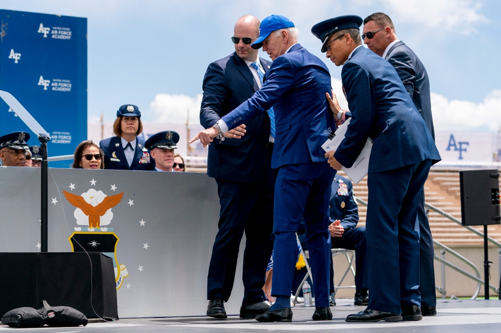 President Joe Biden points to sandbags after falling on stage during the 2023 United States Air Force Academy Graduation Ceremony.