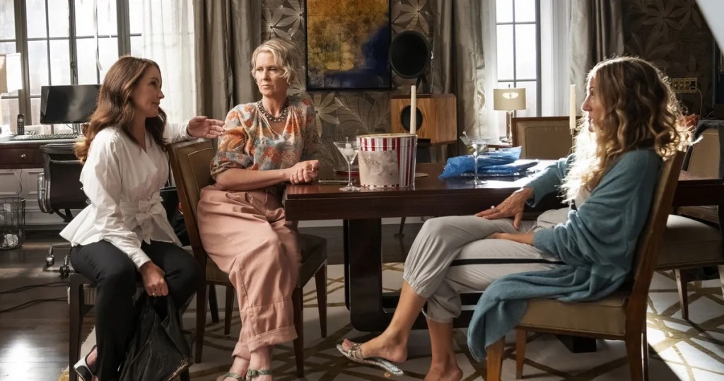 Charlotte (Kristin Davis), Miranda (Cynthia Nixon) and Carrie (Sarah Jessica Parker) sit around a table. 