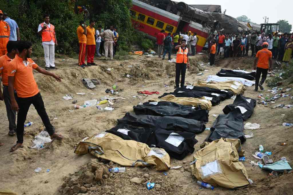 Hundreds of bodies were covered and laid on the ground near the tracks. 
