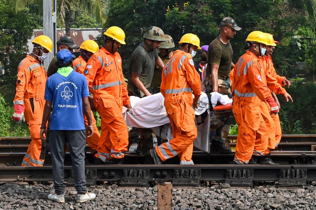 Rescue workers carry the body of a victim along the tracks at the accident site of a three-train collision near Balasore.
