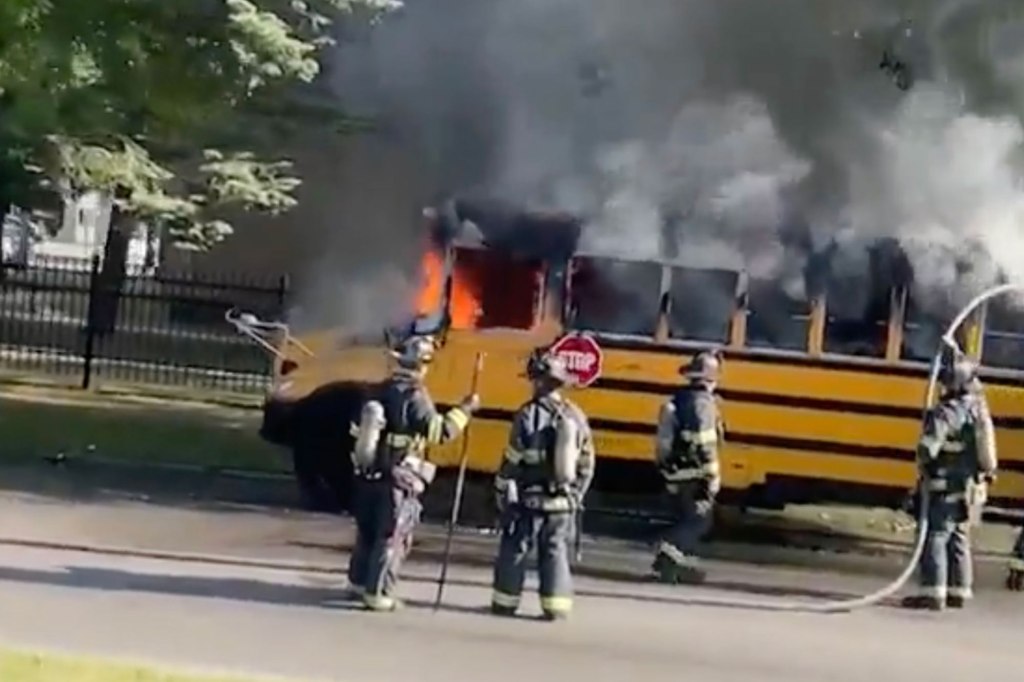school bus on fire with firefighters on scene