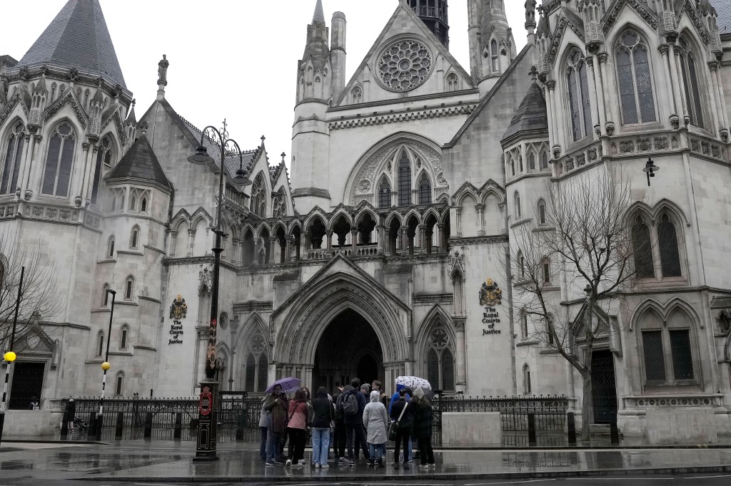 People crowded by the door of the Royal Court of Justice, in London, which is overseeing the lawsuits. 