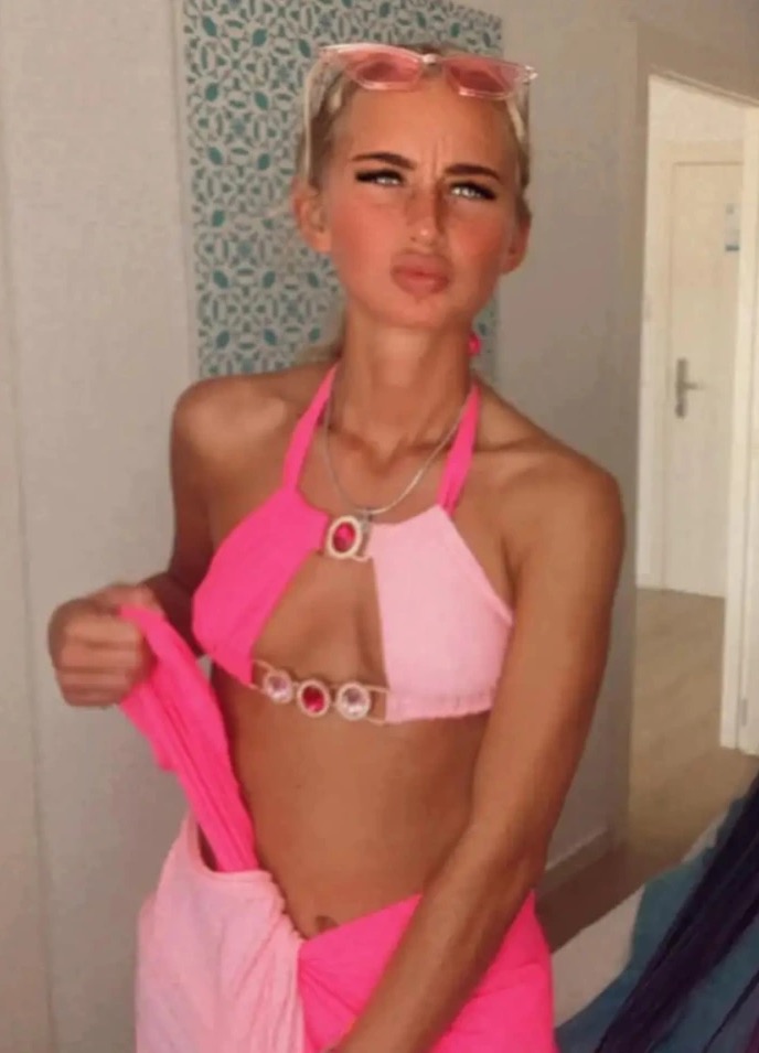 Georgia Bilham poses for a photo in a pink bikini and sarong 
