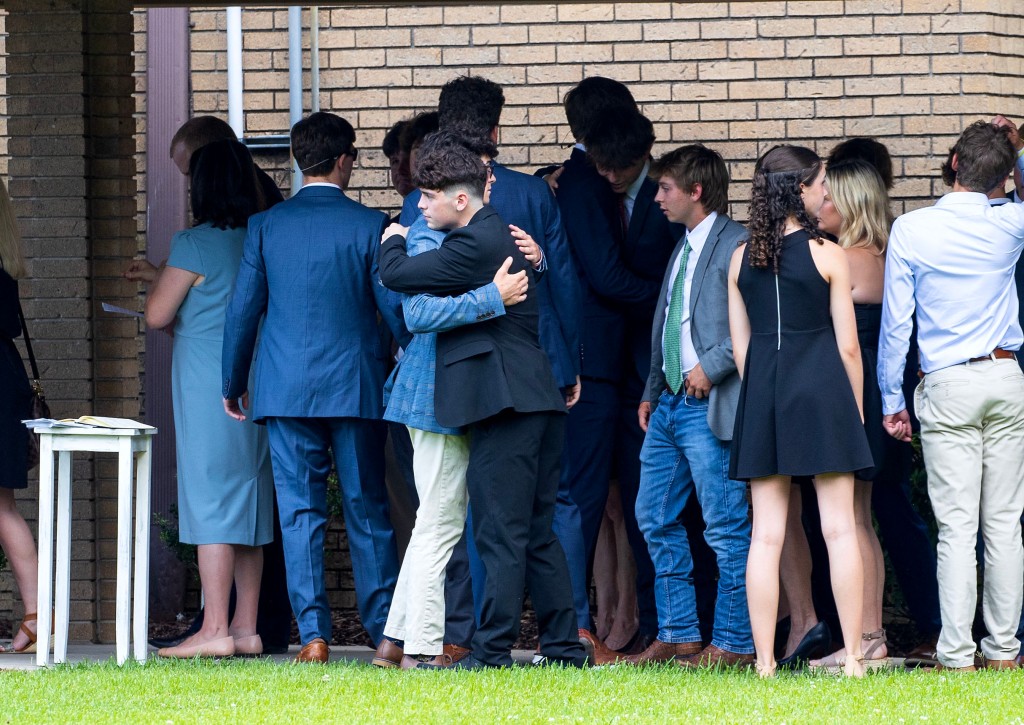 Friends and family of Robbins sharing an embrace at the service.