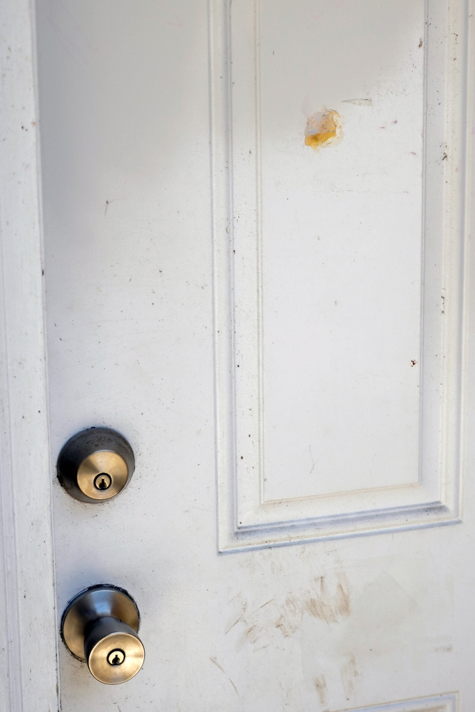 A patched bullet hole, upper right, is seen on a door where Ajike Owens, a 35-year-old mother of four, was shot and killed 