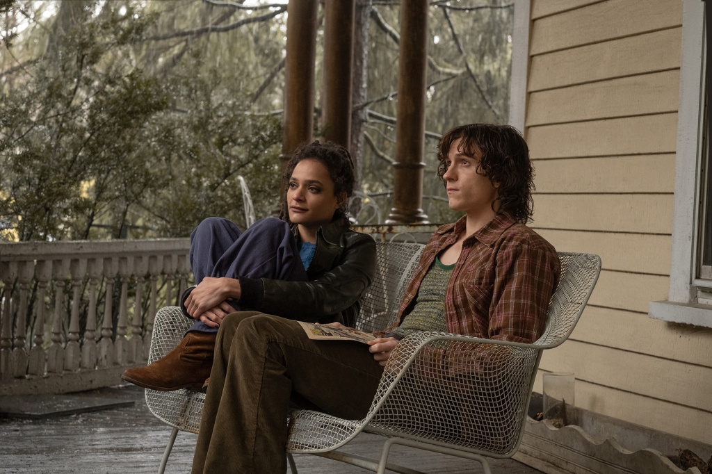 Tom Holland and Sasha Lane sitting on a porch. 
