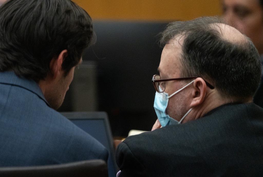 Bryan Patrick Miller talks to his lawyer in court.