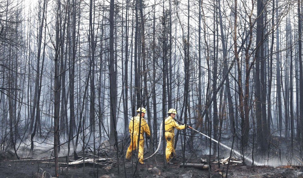 Firefighters spray hot spots in Shelburne County, Nova Scotia earlier this week.