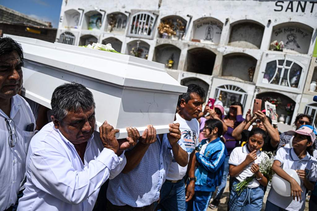 Jose Ancajima (L), father of 10-year-old Fer Maria Ancajima who died from dengue fever, carries her coffin before her burial at a graveyard in Catacaos.