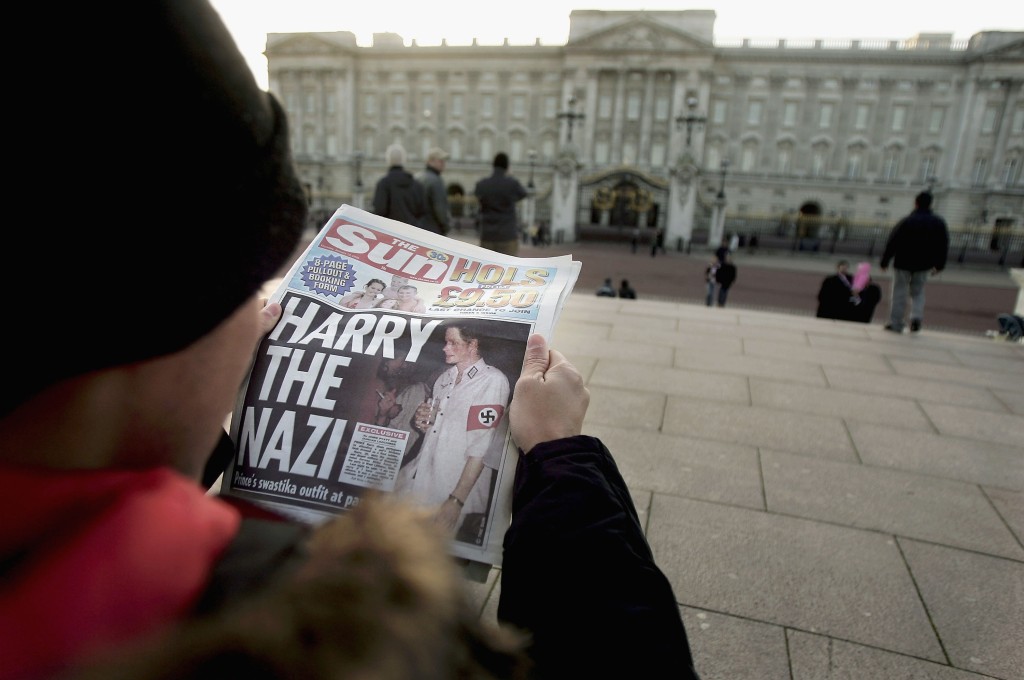 A man reads the "Harry the Nazi" scandal story in a tabloid outside of Buckingham Palace. 