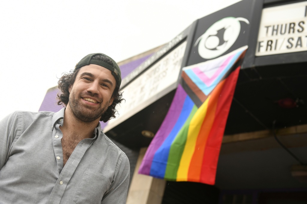 Planet Ant Theatre executive director Darren Shelton with the pride flag on the front of his theatre in Hamtramck.