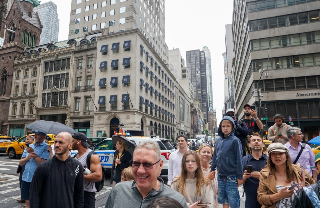 A crowd gathers outside the building.