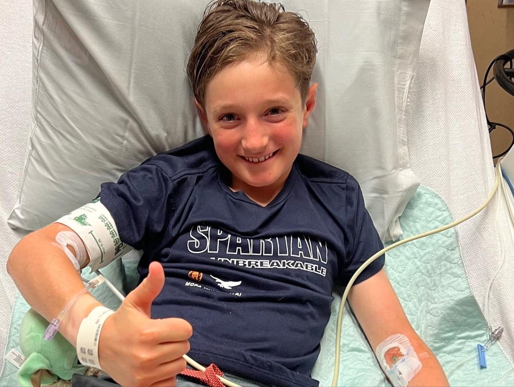 Ethan Vogel giving thumbs up from hospital bed