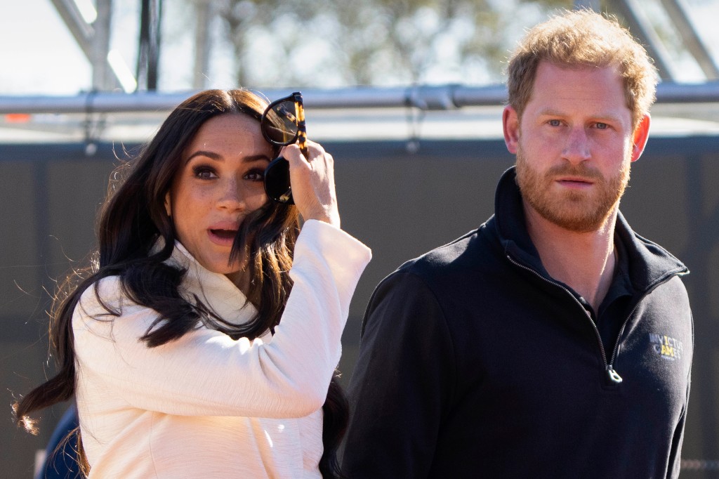 Harry and Meghan outside looking serious. 